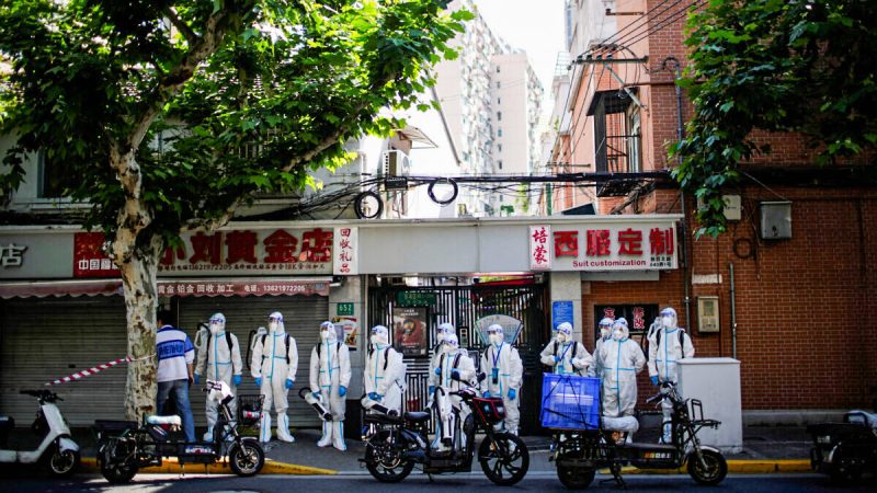 Рабочие в защитных костюмах стоят на улице, проводя дезинфекцию во время блокировки в Шанхае 18 мая 2022 года. (Aly Song/Reuters)  | Epoch Times Россия
