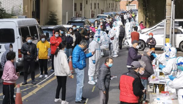Люди стоят в очереди, чтобы сдать мазок во время общегородской кампании по тестированию на COVID-19 1 апреля 2022 года в Шанхае, Китай. (Zhang Suoqing/VCG via Getty Images)