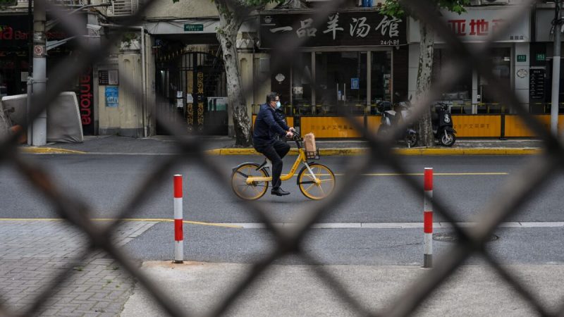Вид на улицу сквозь забор комплекса, закрытого на замок, во время блокировки COVID-19 в районе Цзинъань в Шанхае, Китай, 19 мая 2022 года. (Hector Retamal/AFP via Getty Images)  | Epoch Times Россия