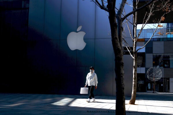 Мужчина в маске проходит мимо магазина Apple в элитном торговом районе Пекина, Китай, 4 марта 2020 года. (Reuters/Thomas Peter)