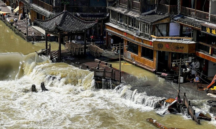 Паводковые воды проносятся через древний город Фэнхуан в центральной китайской провинции Хунань, 4 июня 2022 года. (AP Photo) | Epoch Times Россия