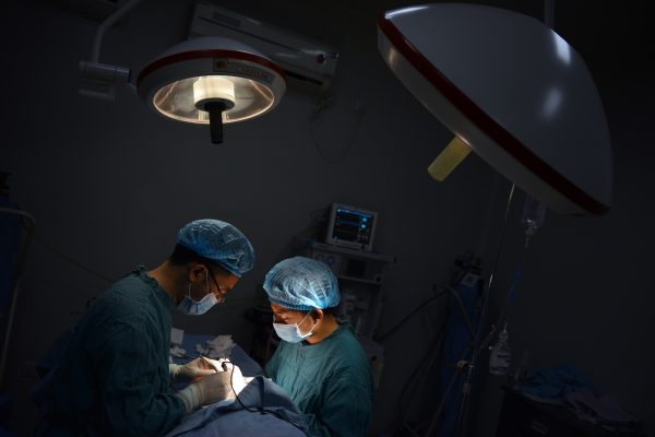 Два врача проводят операцию в городе Чунцине на юго-западе Китая, 9 августа 2013 года. Пациент получил подходящие печень и почку для операции по пересадке всего за месяц в городе Тяньцзинь, сообщает NTD Television. (Peter Parks/AFP/Getty Images)