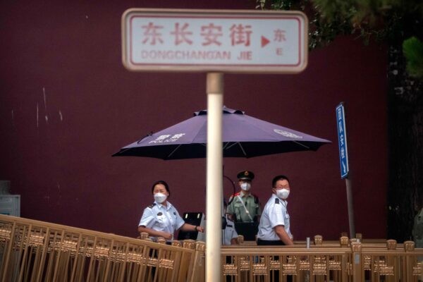 Сотрудники службы безопасности в масках стоят на контрольно-пропускном пункте возле площади Тяньаньмэнь в Пекине, 4 июня 2022 года. (Mark Schiefelbein/AP Photo)