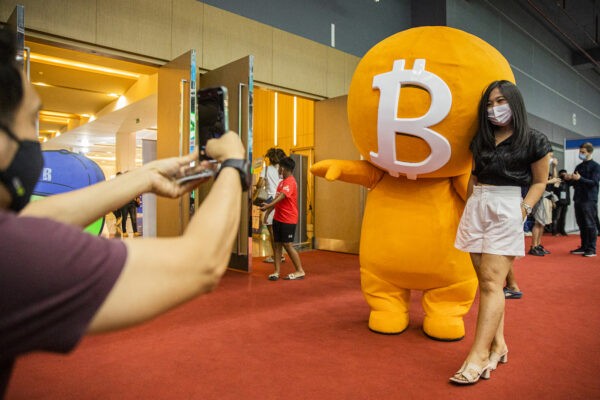 Женщина позирует с талисманом биткоина во время выставки Thailand Crypto Expo 2022 в Бангкоке 14 мая 2022 года. Выставка проходила на фоне обвала мирового рынка. (Lauren DeCicca/Getty Images)
