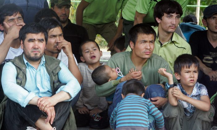 Лица, ищущие убежища, сидят перед посадкой в грузовики, пока сотрудники иммиграционной службы Таиланда сопровождают их в суд в Сонгкхла, южный Таиланд, 15 марта 2014 года. Таиланд вынес приговор десяткам просителей убежища, предположительно принадлежащих к уйгурскому меньшинству Китая, за незаконный въезд, заявил чиновник, несмотря на апелляцию США для их защиты. Tuwaedaniya Meringing/AFP/Getty Images | Epoch Times Россия