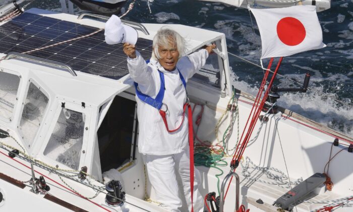 Японец Кеничи Хори на своей парусной лодке после транстихоокеанского путешествия в заливе Осака, западная Япония, 4 июня 2022 года. Фото: Kyodo News via AP | Epoch Times Россия