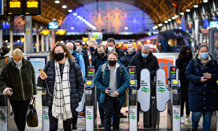 Пассажиры в защитных масках прибывают на вокзал Паддингтон в Лондоне 30 ноября 2021 года. Фото: Leon Neal/Getty Images
 | Epoch Times Россия