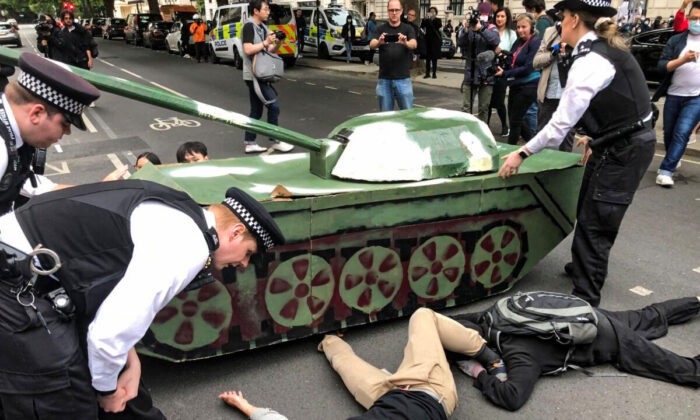 Полиция пытается убрать протестующих, лежащих под макетом танка у посольства Китая во время акции памяти жертв бойни на площади Тяньаньмэнь. Лондон, 4 июня 2022 года. (Peter Simpson/The Epoch Times) | Epoch Times Россия