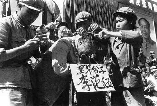Коммунисты вешают плакат на шею китайца во время «Культурной революции» в 1966 году. На плакате написано имя мужчины и обвинение его в принадлежности к «чёрному классу». Фото: (Общественное достояние)