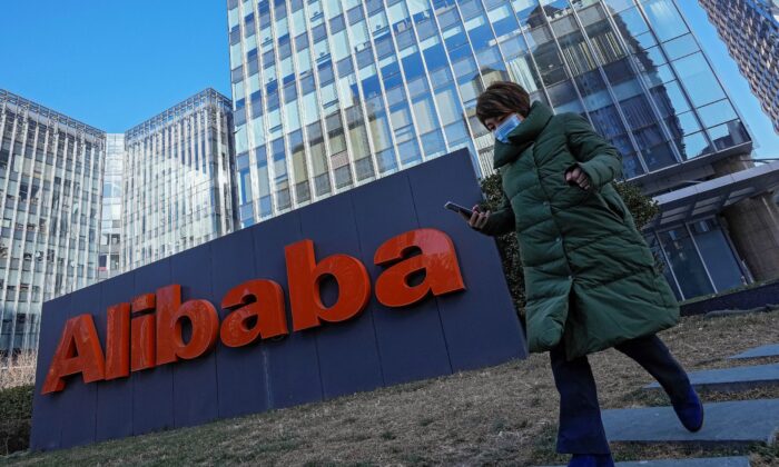 Женщина на фоне офиса китайской фирмы электронной коммерции Alibaba в Пекине, Китай, 13 декабря 2021 года. (Andy Wong/AP Photo)
 | Epoch Times Россия