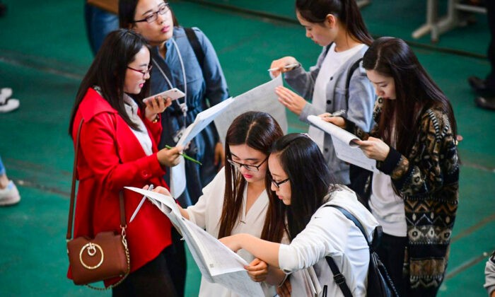 Молодые люди рассматривают объявления на ярмарке вакансий в Шэньянском аэрокосмическом университете в Шэньяне, северо-восточная китайская провинция Ляонин, 13 мая 2017 года. (STR/AFP/Getty Images) | Epoch Times Россия