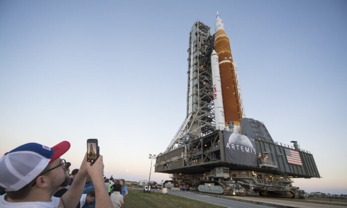 Приглашённые гости и сотрудники НАСА фотографируются во время первого выкатывания ракеты НАСА Space Launch System (SLS) с космическим кораблём Orion на борту из отсека 3 сборочного корпуса в Космическом центре имени Кеннеди на мысе Канаверал, штат Флорида, 17 марта 2022 года. (Aubrey Gemignani/NASA via AP) | Epoch Times Россия