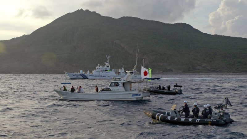 Корабль береговой охраны Японии и катера (сзади и справа) плывут рядом с рыбацкой лодкой японских активистов (в центре) возле группы спорных островов, называемых Китаем Дяоюйдао, а Японией - Сенкаку, 18 августа 2013 года. (Emily Wang/AP Photo)  | Epoch Times Россия