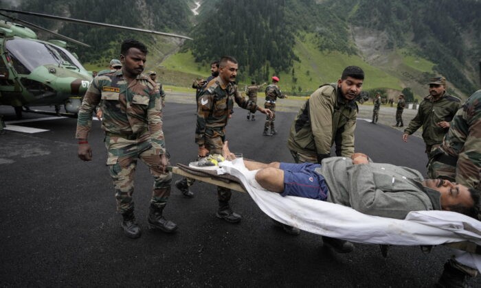 Солдаты индийской армии несут пострадавшего от ливня на лечение в Балтале, в 105 км к северо-востоку от Шринагара, Кашмир, Индия, 9 июля 2022 года. (Mukhtar Khan/AP Photo)
 | Epoch Times Россия