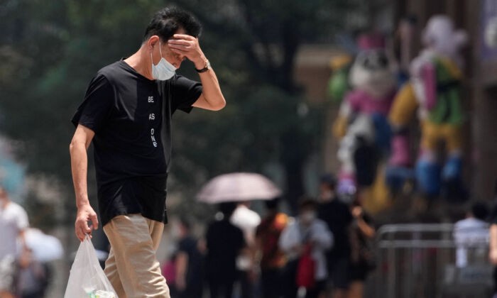 Мужчина на улице во время предупреждения о сильной жаре в Шанхае, 13 июля 2022 г. (Aly Song/Reuters)
 | Epoch Times Россия