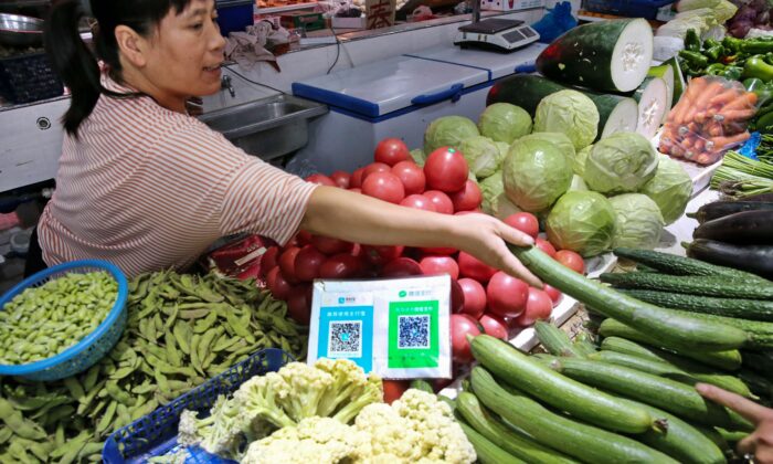 QR-коды Alipay и Wechat для онлайн-платежей на овощном рынке в Наньтуне в провинции Цзянсу. 10 сентября 2018 года. (STR/AFP via Getty Images) | Epoch Times Россия
