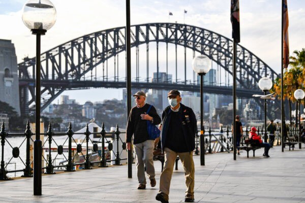 Мужчина в маске прогуливается перед мостом Харбор-Бридж в Сиднее, Новый Южный Уэльс, Австралия, 22 июля 2020 года. (Saeed Khan/AFP via Getty Images)