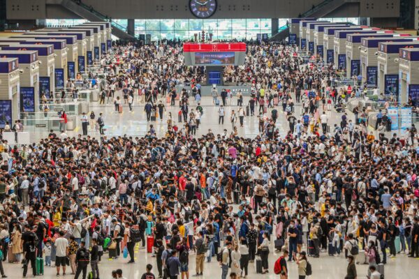 Пассажиры ждут прибытия поезда на восточной железнодорожной станции в Чжэнчжоу, в центральной китайской провинции Хэнань, 30 сентября 2021 года. (STR/AFP via Getty Images)