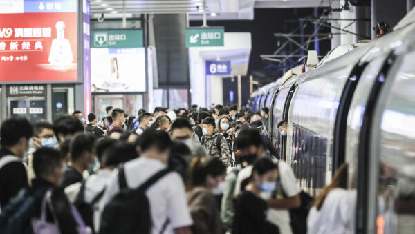 Пассажиры садятся в поезд на железнодорожной станции в Хуайане, китайская провинция Цзянсу, 7 октября 2021 года. (STR/AFP via Getty Images)