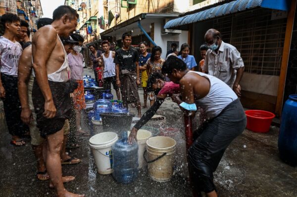 Люди наполняют ёмкости в Янгоне 14 марта 2022 года в условиях нехватки воды из-за отключения электричества в городе. (STR/AFP via Getty Images)