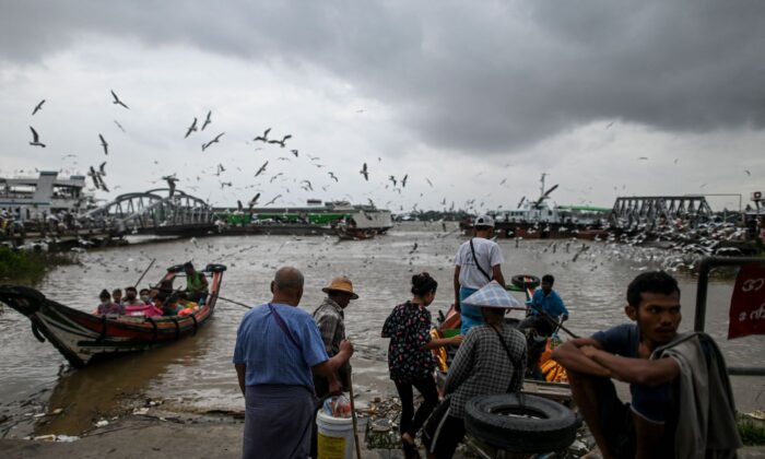 Люди садятся на паром на реке Янгон в Янгоне 22 марта 2022 года. (AFP via Getty Images)
 | Epoch Times Россия