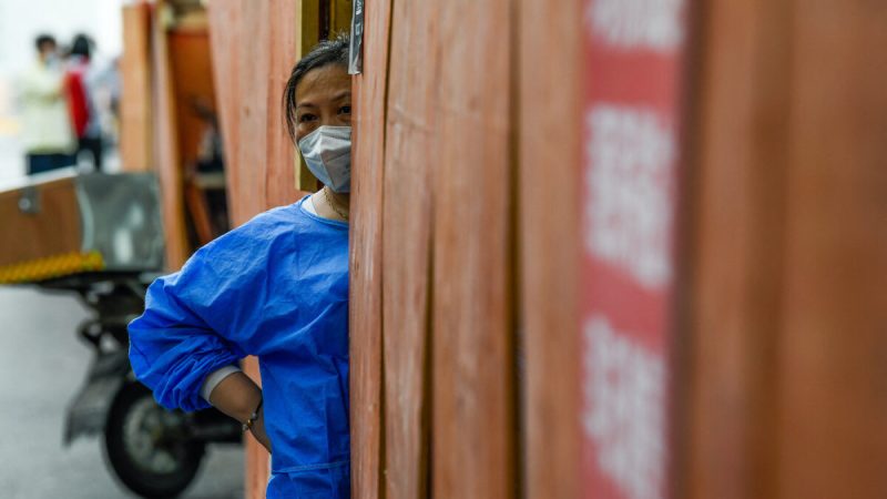 Волонтёр стоит за ограждением в жилом районе, находящемся под запретом COVID-19, в шанхайском районе Хуанпу 22 июня 2022 года. (Liu Jin/AFP via Getty Images)  | Epoch Times Россия