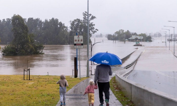 Люди смотрят на затопленный Виндзорский мост вдоль реки Хоксбери в пригороде Виндзора в Сиднее, Австралия, 4 июля 2022 года. (Jenny Evans/Getty Images) | Epoch Times Россия
