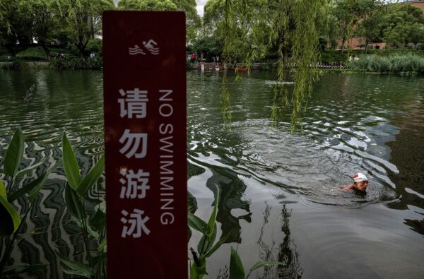 Мужчина купается в реке Лянма в жаркий летний день в Пекине, Китай, 12 июля 2022 года. (Kevin Frayer/Getty Images)