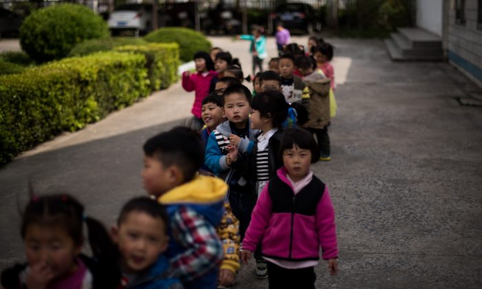 Дети на школьном дворе некогда шумной Технической средней школы в Рудуне, провинция Цзянсу, 17 апреля 2015 года. (Johannes Eisele/AFP/Getty Images) | Epoch Times Россия