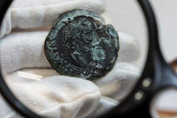 Редкая бронзовая монета возрастом 1850 лет, обнаруженная у израильского прибрежного города Хайфа, выставлена в офисе Управления древностей Израиля в Иерусалиме, 26 июля 2022 года. (Tsafrir Abayov/AP Photo)
