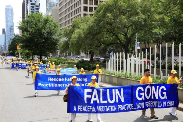 Последователи Фалуньгун участвуют в параде в центре Торонто 17 июля 2022 года, призывая прекратить преследование своих единоверцев в Китае. (Evan Ning/The Epoch Times)