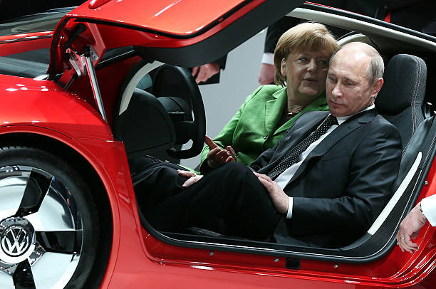 Канцлер Германии Ангела Меркель и президент России Владимир Путин в автомобиле Volkswagen XL 1 Hybrid, 12 апреля 2013 года. Фото: RONNY HARTMANN/AFP via Getty Images  | Epoch Times Россия