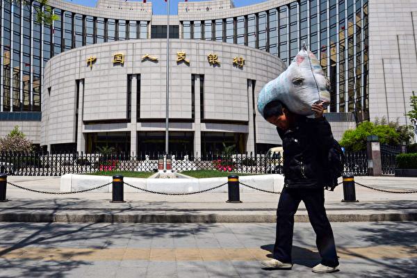 На фотографии китайский рабочий-мигрант проходит мимо Народного банка Китая в Пекине, 1 мая 2013 года. (Mark Ralston/AFP)  | Epoch Times Россия