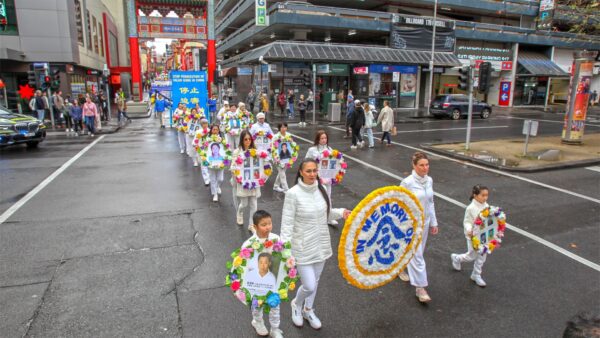 Участницы в белых одеждах держат венки 9 июля 2022 года в Мельбурне, Австралия, в память о практикующих, погибших в результате преследования Фалуньгун в Китае. (Chen Ming/Epoch Times)