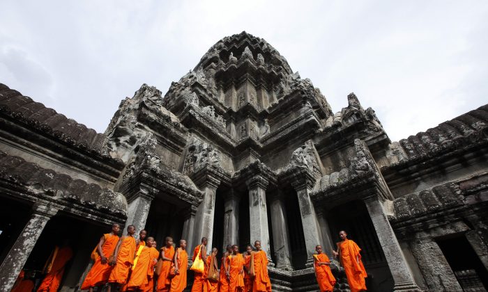 Буддийские монахи прогуливаются по древнему храму Ангкор-Ват в провинции Сиемреап в Камбодже 16 июля 2010 года. (Eugene Hoshiko/AP Photo)
 | Epoch Times Россия