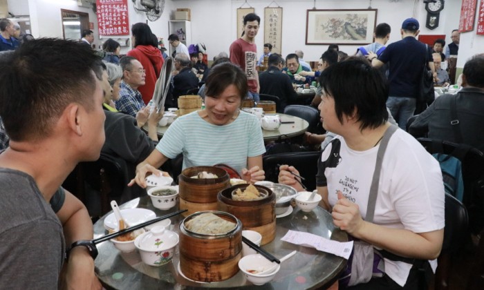 Чайный дом Lin Heung, открытый в 1927 году, предлагает традиционный димсам. Посетители наслаждаются едой в марте 2019 года. (TM Chan/The Epoch Times)