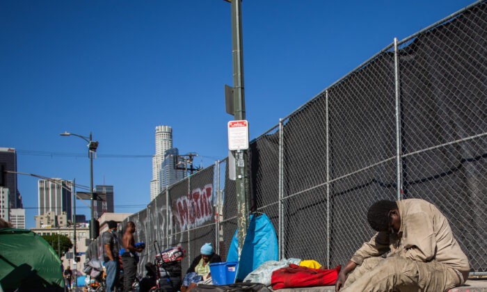 Бездомные на тротуаре возле штаб-квартиры некоммерческой Midnight Mission в районе Скид Роу в центре Лос-Анджелеса, 25 ноября 2021 года. (APU GOMES/AFP через Getty Images)
 | Epoch Times Россия