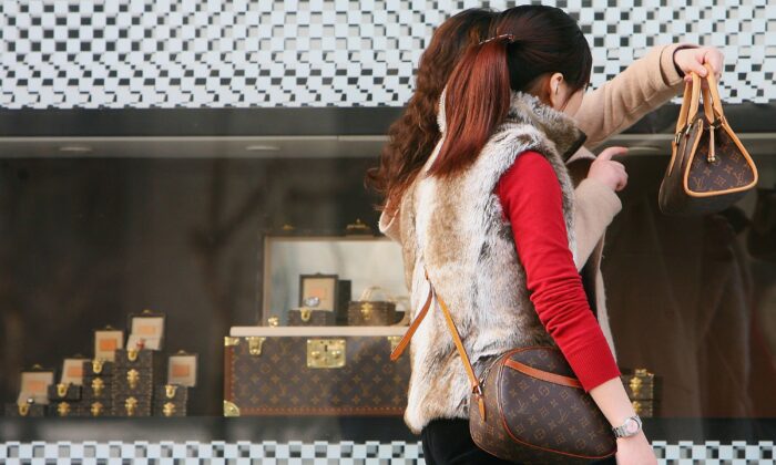 Китайские женщины рассматривают сумки, которые они купили в магазине Louis Vuitton в Шанхае, Китай, 10 марта 2006. (China Photos/Getty Images)
 | Epoch Times Россия