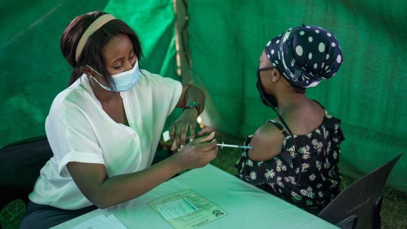 Медицинский работник вводит вакцину Johnson & Johnson от COVID-19 женщине возле избирательного участка в зале Копанонг в Соуэто, ЮАР, 1 ноября 2021 года. (Michele Spatari/AFP via Getty Images)  | Epoch Times Россия