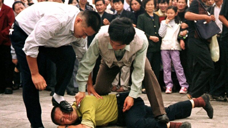 Полицейские в штатском жестоко обращаются с протестующим Фалуньгун на площади Тяньаньмэнь в Пекине, 1 октября 2000 г. (Chien-min Chung/AP)  | Epoch Times Россия