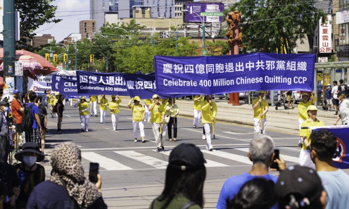 Люди смотрят на парад в честь выхода 400 млн китайцев из Коммунистической партии Китая и связанных с ней организаций, в Торонто 6 августа 2022 года. (Evan Ning/The Epoch Times)
 | Epoch Times Россия