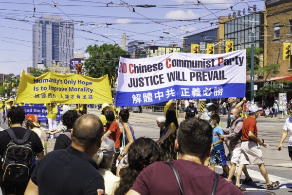 Люди смотрят на парад в центре Торонто в честь выхода 400 млн китайцев из Коммунистической партии Китая и связанных с ней организаций, 6 августа 2022 года. (Evan Ning /The Epoch Times)