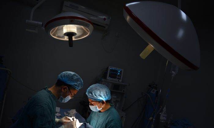Врачи проводят операцию в Чунцине, Китай, 9 августа 2013 года. (Peter Parks/AFP/Getty Images)
 | Epoch Times Россия