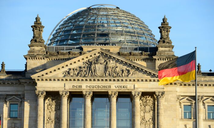 Государственный флаг Германии перед зданием Рейхстага, где размещается немецкий парламент Бундестаг, 16 декабря 2013 года. (John Macdougall/AFP via Getty Images) | Epoch Times Россия