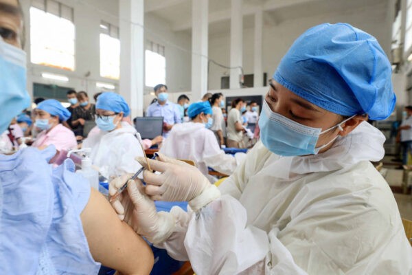 Медицинский работник вводит вакцину Sinovac против коронавируса жителю в Ронгане, в южной китайской провинции Гуанси. 3 июня 2021 года. (STR/AFP via Getty Images)