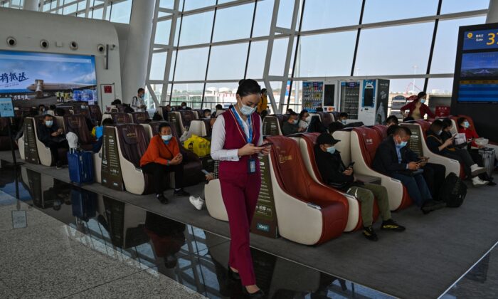Сотрудница авиакомпании проверяет свой телефон в международном аэропорту Тяньхэ в Ухане, провинция Хубэй в центральной части Китая, 25 октября 2021 года. (Hector Retamal/AFP via Getty Images)
 | Epoch Times Россия