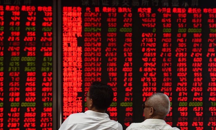 Инвесторы следят за движением цен на акции в компании по ценным бумагам в Пекине 15 июня 2016 года. (Greg Baker/AFP/Getty Images)
 | Epoch Times Россия