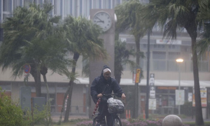 Мужчина на велосипеде пробирается сквозь дождь в Миядзаки, южная Япония, 18 сентября 2022 года, когда тайфун «Нанмадол» обрушил на регион сильный ветер и проливной дождь. (Kyodo News via AP)
 | Epoch Times Россия