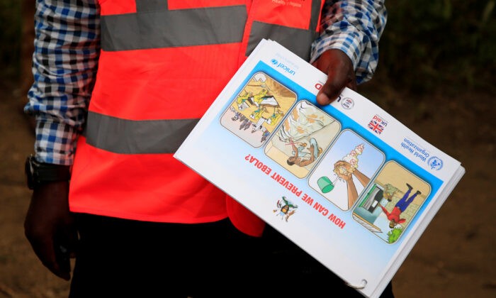Угандийский работник здравоохранения показывает информационную листовку о вирусе Эбола и способах предотвращения его распространения жителям деревни Кирембо, недалеко от границы с Демократической Республикой Конго, в округе Касесе, Уганда, 15 июня 2019 года. (James Akena/Reuters) | Epoch Times Россия