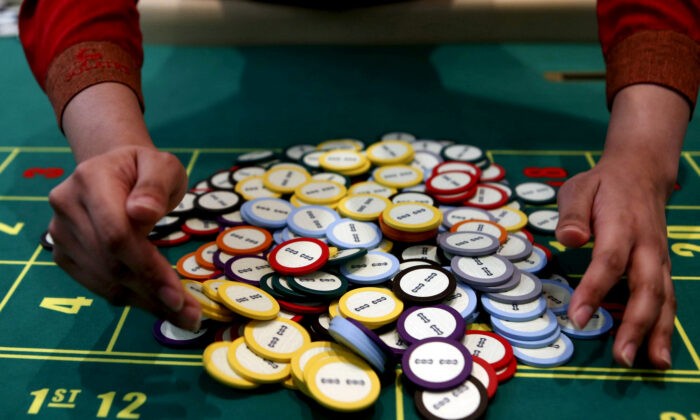 Крупье казино собирает фишки за столом для рулетки в городе Пасай, Манила, Филиппины, 27 марта 2015 г. (Erik De Castro/Reuters) | Epoch Times Россия